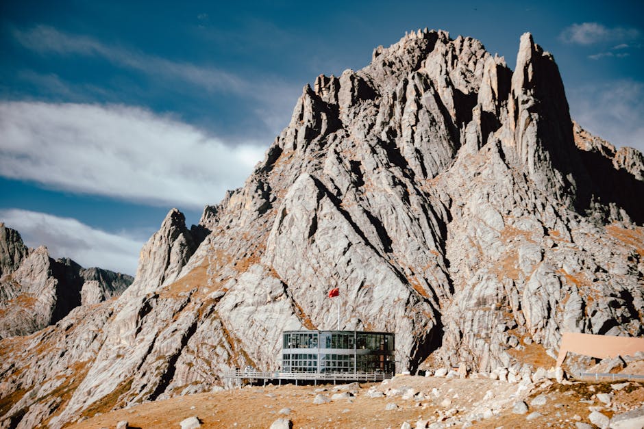 A striking modern building nestled in a dramatic mountain landscape under a clear sky