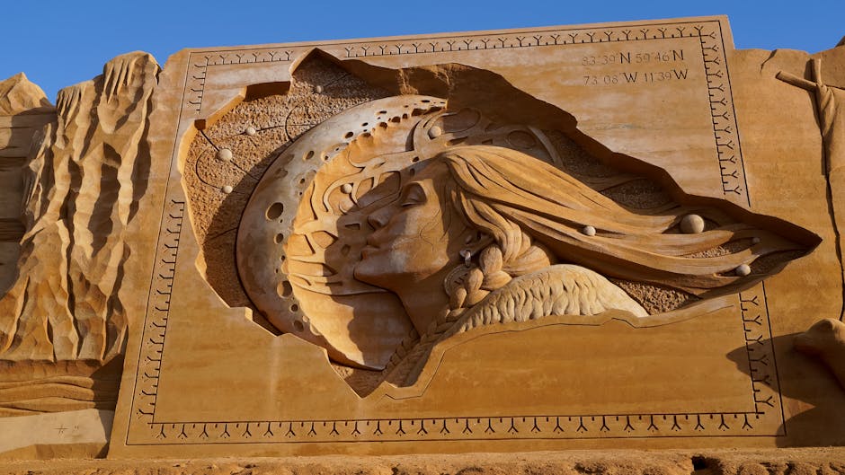 Detailed sand sculpture at Søndervig, Denmark, showcasing celestial and human form art.