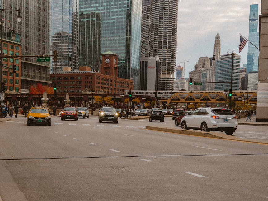 Bustling Chicago street with cars and skyscrapers on a cloudy day.
